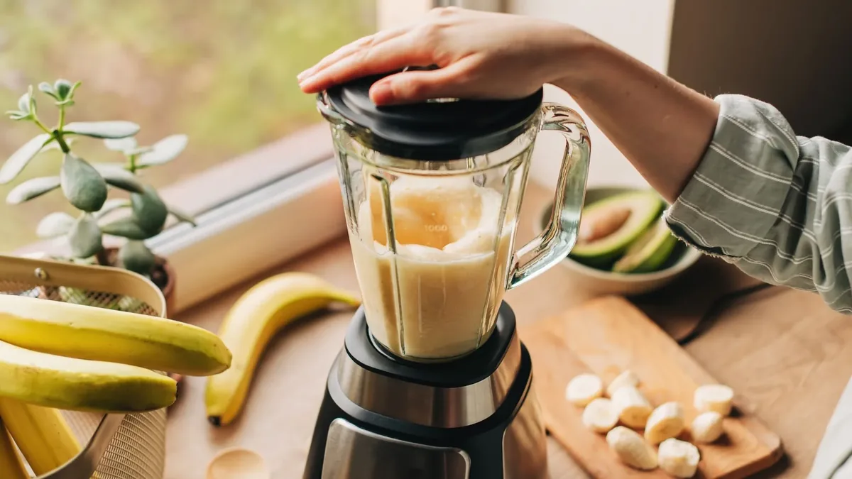 Mixage d'un smoothie épais à la banane dans un blender à bol en verre