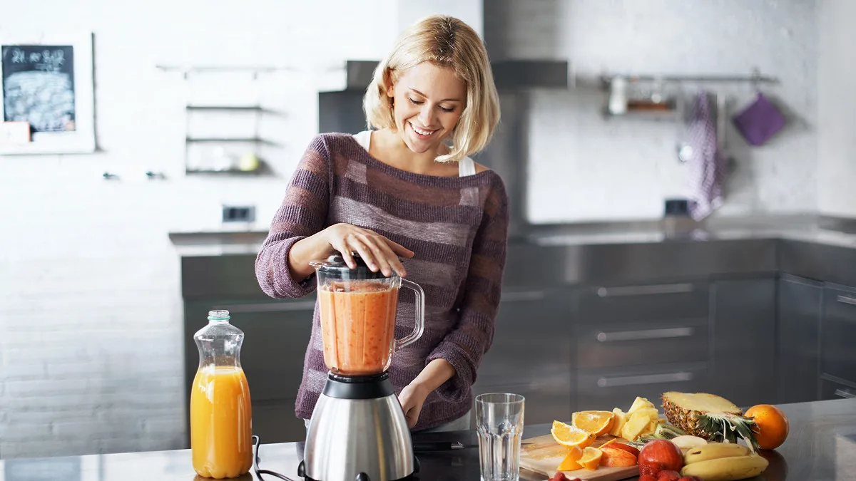 Préparation d'un smoothie au blender dans une cuisine ouverte