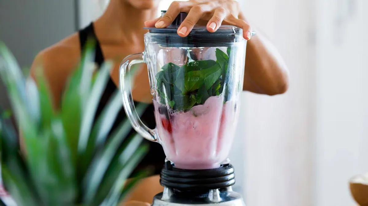 Dégustation d'un smoothie vert fraîchement mixé au blender